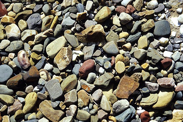 Steine in den unterschiedlichsten Farben liegen im Bachbett