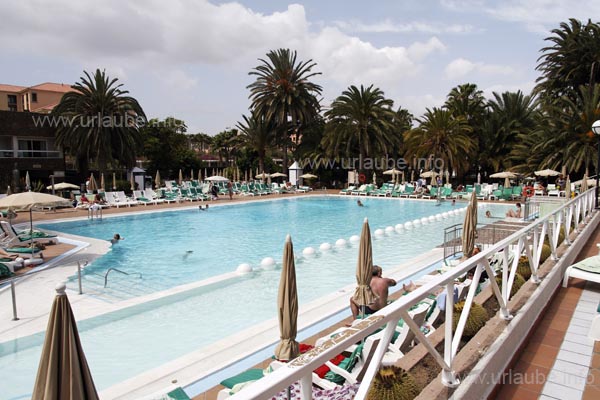 The tall palms provide an impressive coulisse to the obsolete poolscape.