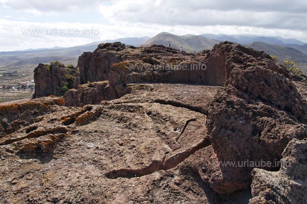 In the ground there are some deep crescent-shaped grooves carved.