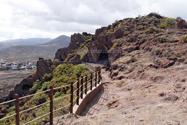 The way to the living caves at the back is secured by a balustrade.