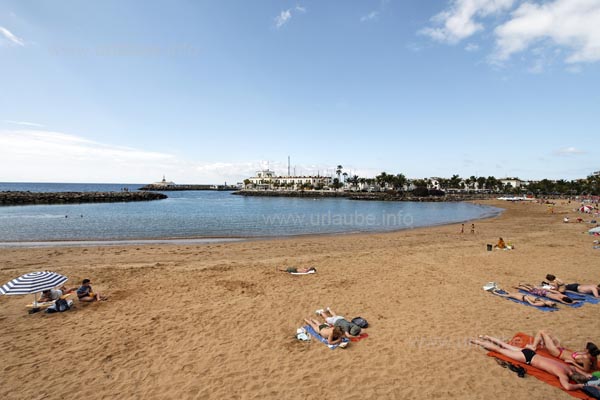 The beach goes shallowly into the water and it is protected by a mole.