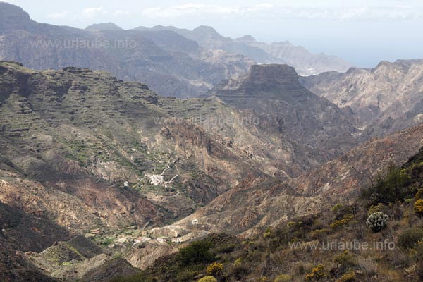 The small village El Chorrillo is only little visible. It is located as a tiny dot right at the hillside of the Roque Bentayga at the front.