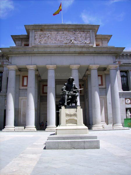 One entrance of the museum El Prado, in the foreground, a monument of Vel&aacute;zquez is visible