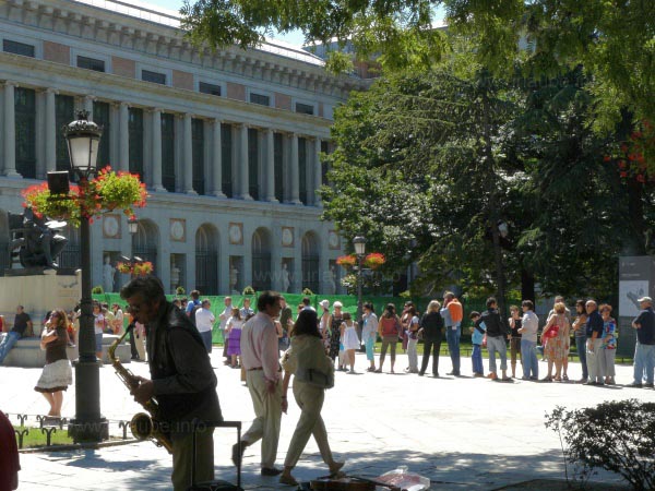 In the background there are people queueing in a day where the entrance to the Prado is free. 