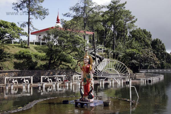 A monument on a small platform at the edge of the lake
