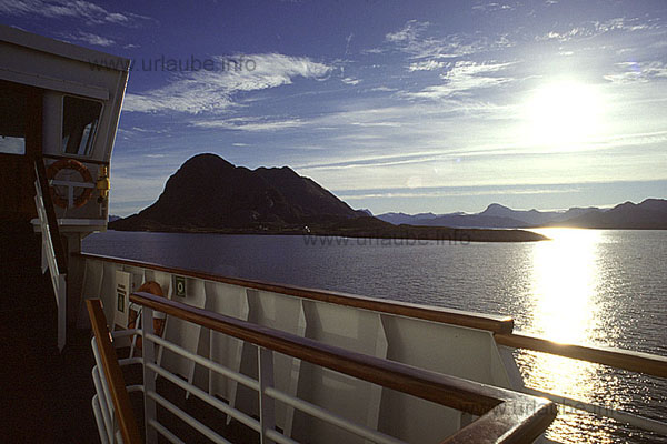 In the distance, over the grey peaks of the mainland, the masses o ice of the glacier of the Svartisen