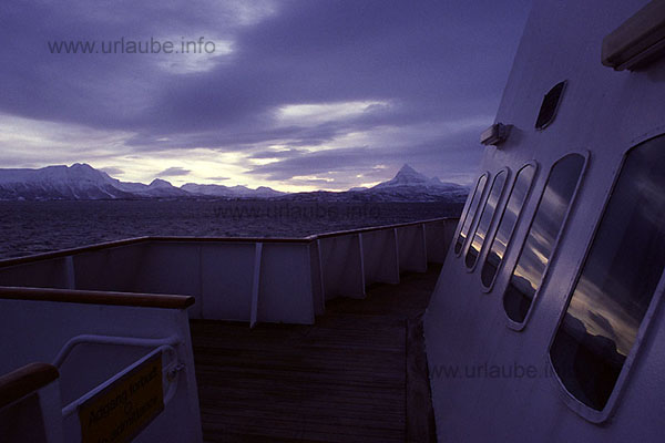 In the windows of the bungalows, the landscape of the islands Rolla and And&ouml;rja is reflected. At the right, there is the pyramide of the peak of the Rolla that is heighted 926 m.