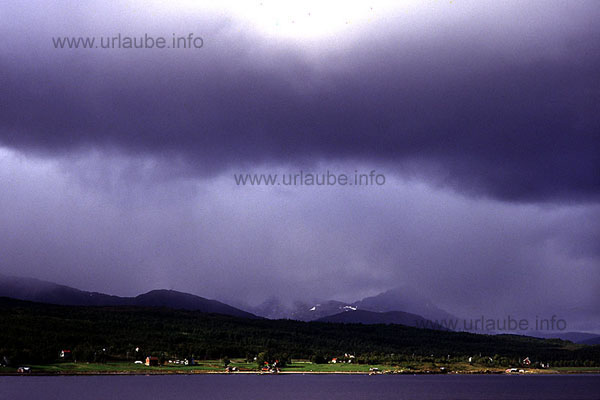 Island Senja. At the shores, alongside the waterway, quiet hamlets and friendly green.