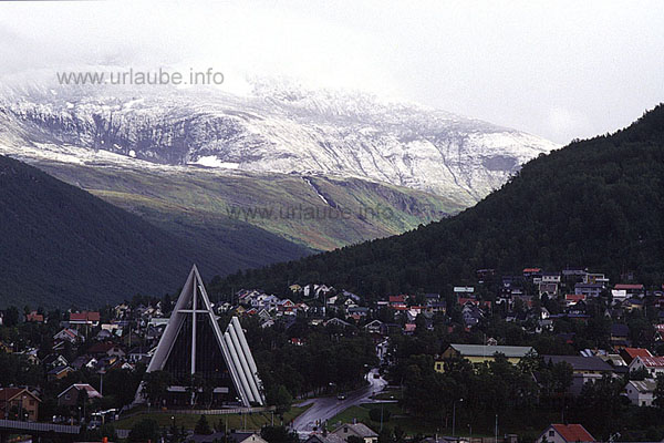 Still before the ship lands in Troms&ouml;, a view to the Arctic Sea Cathedral and the first mercuries of the approaching winter. A trip with the Hurtigruten can also be a travel through different seasons. If one can still enjoy the last warm days of summer in the south, in the north of Norway, the autumn is perceivable by the first snow in the mountains.