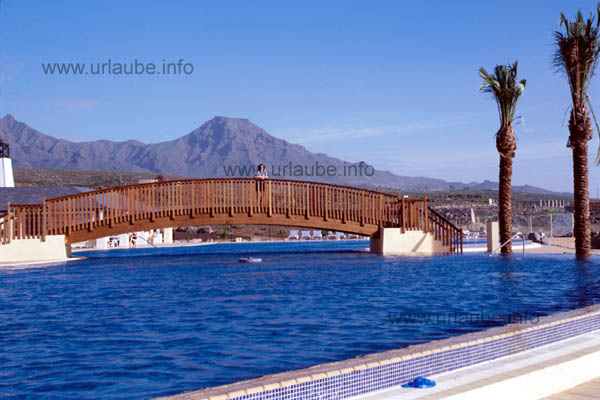 View to the bridge at the sea pool with the mountains of Adeje in the background