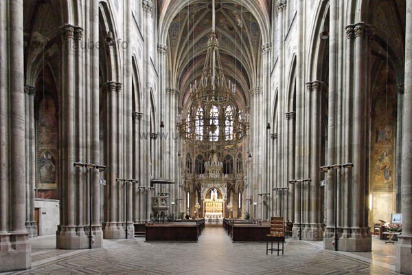 The lofty powerful columns in the interior of the Votivkirche appear awe-inspiring .